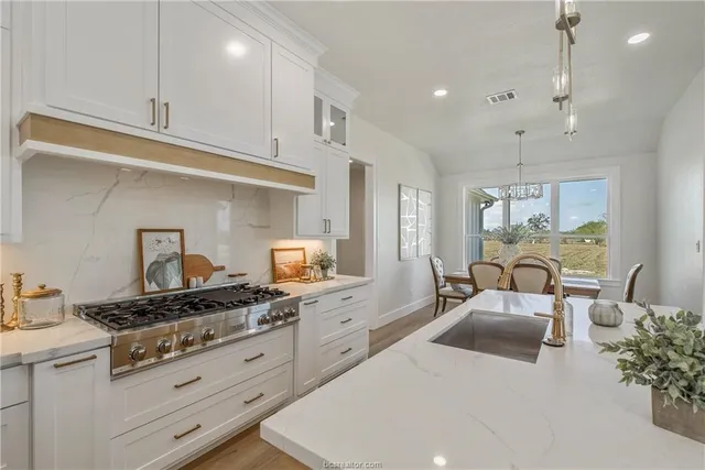 a kitchen with white cabinets and appliances