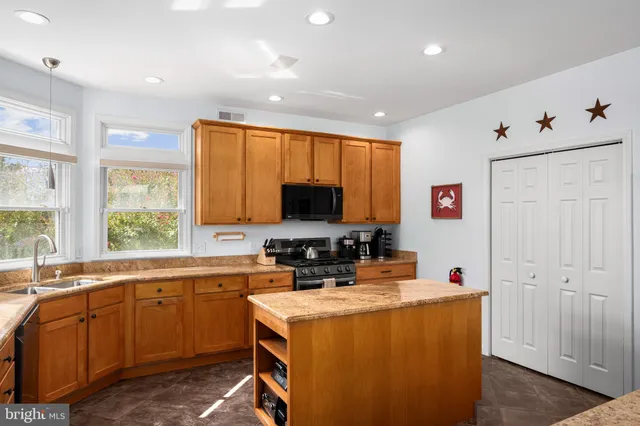 a kitchen with a sink stove top oven and refrigerator