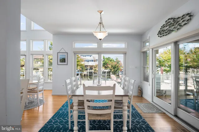 a view of a dining room with furniture large windows and wooden floor