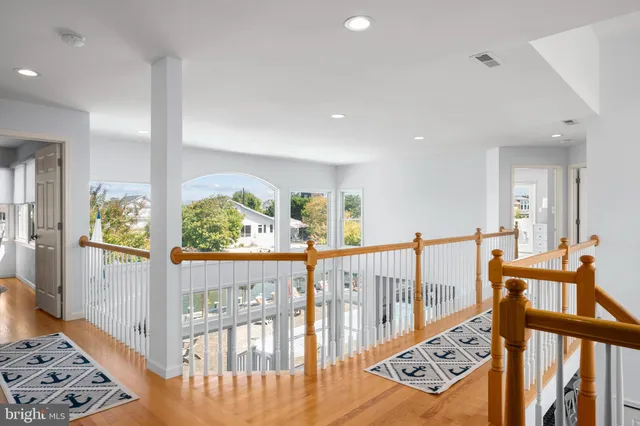 a view of a hallway with dining room and wooden floor