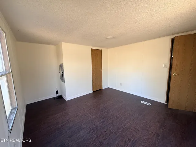 a view of an empty room with wooden floor