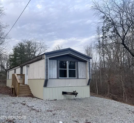 a view of a house with a yard and wooden fence