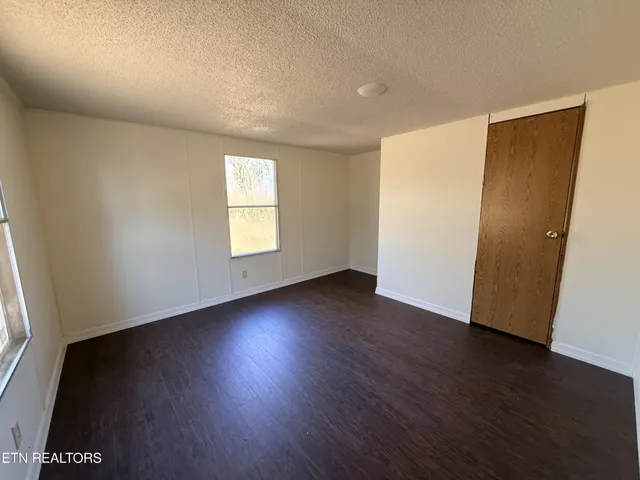 an empty room with wooden floor and a window