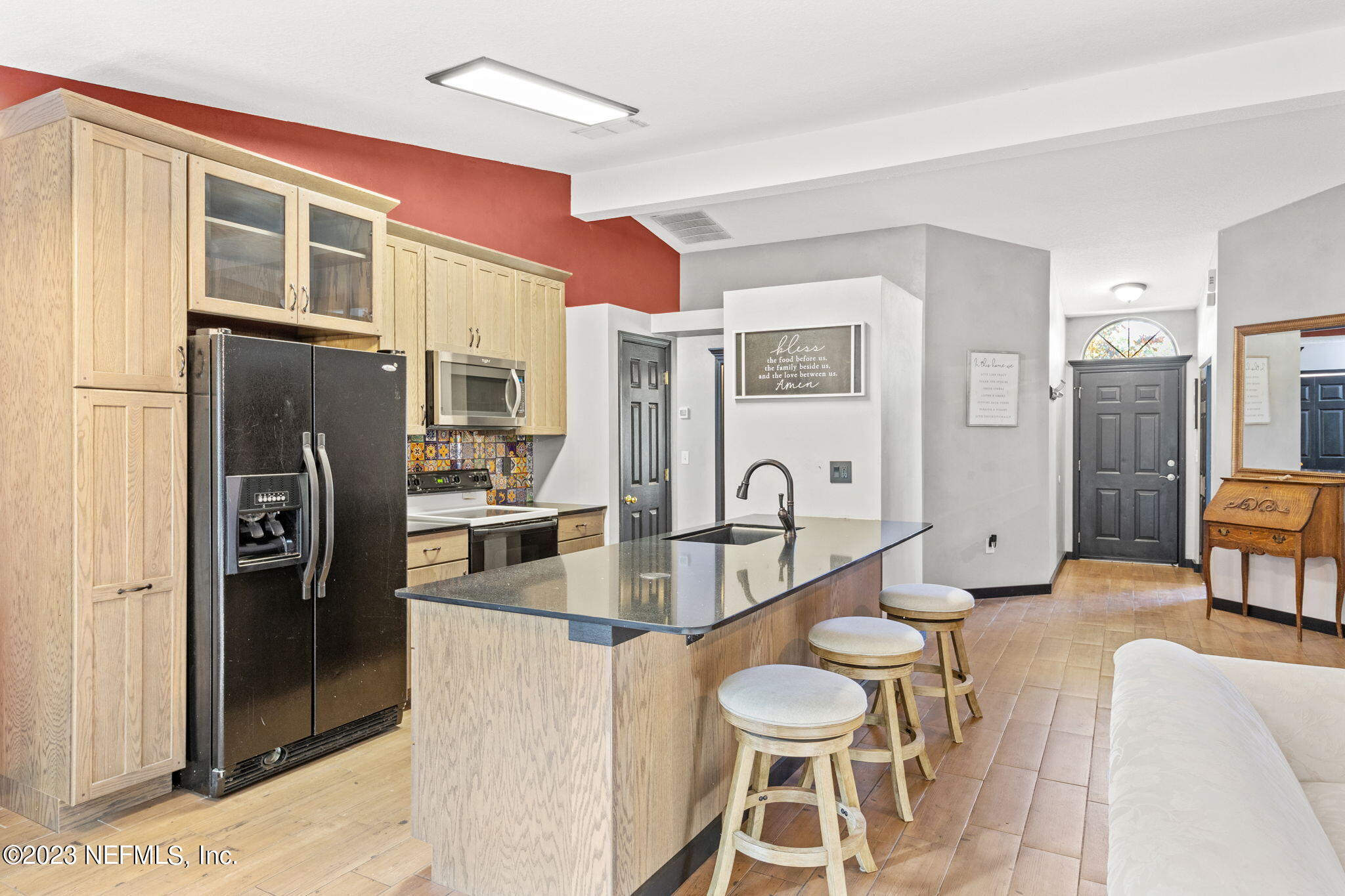 944 North Lilac Loop St. Johns, FL 32259 - Photo 2 of 32 a kitchen with stainless steel appliances kitchen island granite countertop a refrigerator a stove a dining table and chairs with wooden floor