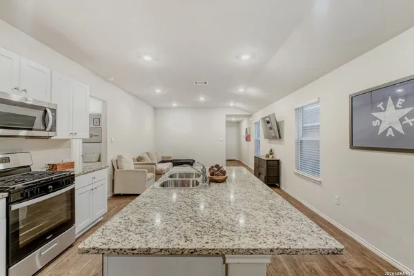 a large kitchen with stainless steel appliances granite countertop a stove and a sink