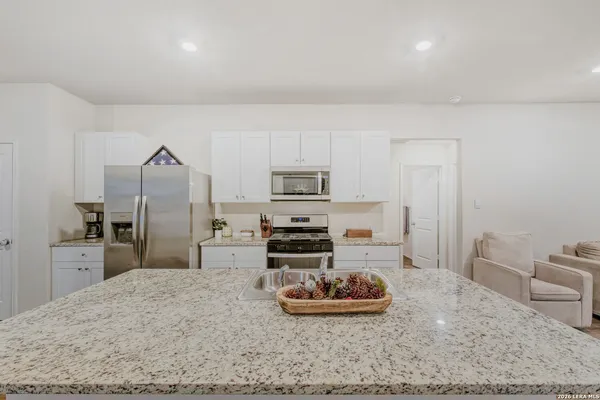 a kitchen with stainless steel appliances kitchen island granite countertop a sink refrigerator and stove