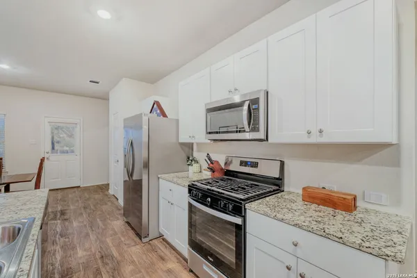 a kitchen with stainless steel appliances granite countertop a stove a sink and a refrigerator