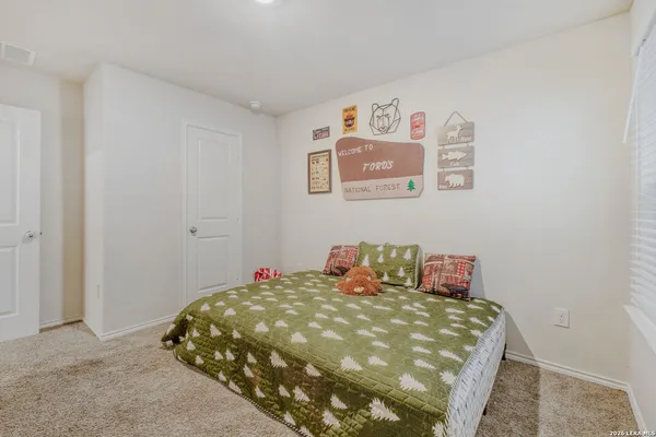 a bedroom with a bed and painting on the wall