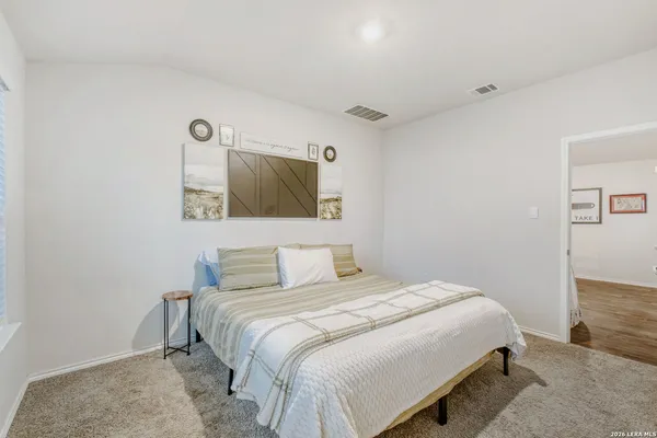 a bedroom with a bed and painting on the wall