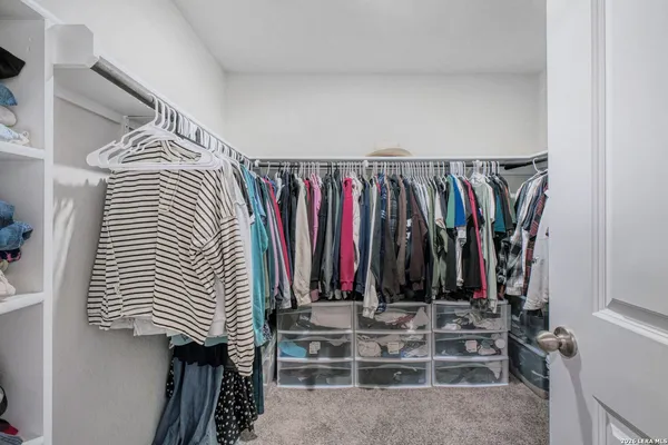 a view of walk in closet with clothes