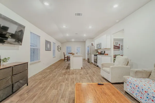 a living room with furniture and a wooden floor