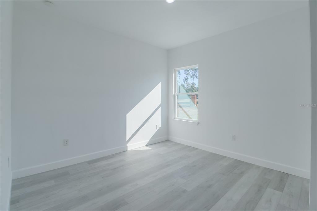 3110 Southwest 127th Lane Road Ocala, FL 34473 - Photo 14 of 17 an empty room with wooden floor and windows