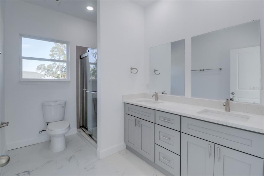 3110 Southwest 127th Lane Road Ocala, FL 34473 - Photo 17 of 17 a bathroom with a toilet sink and mirror