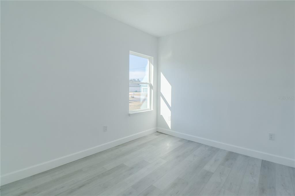 3110 Southwest 127th Lane Road Ocala, FL 34473 - Photo 5 of 17 an empty room with wooden floor and windows