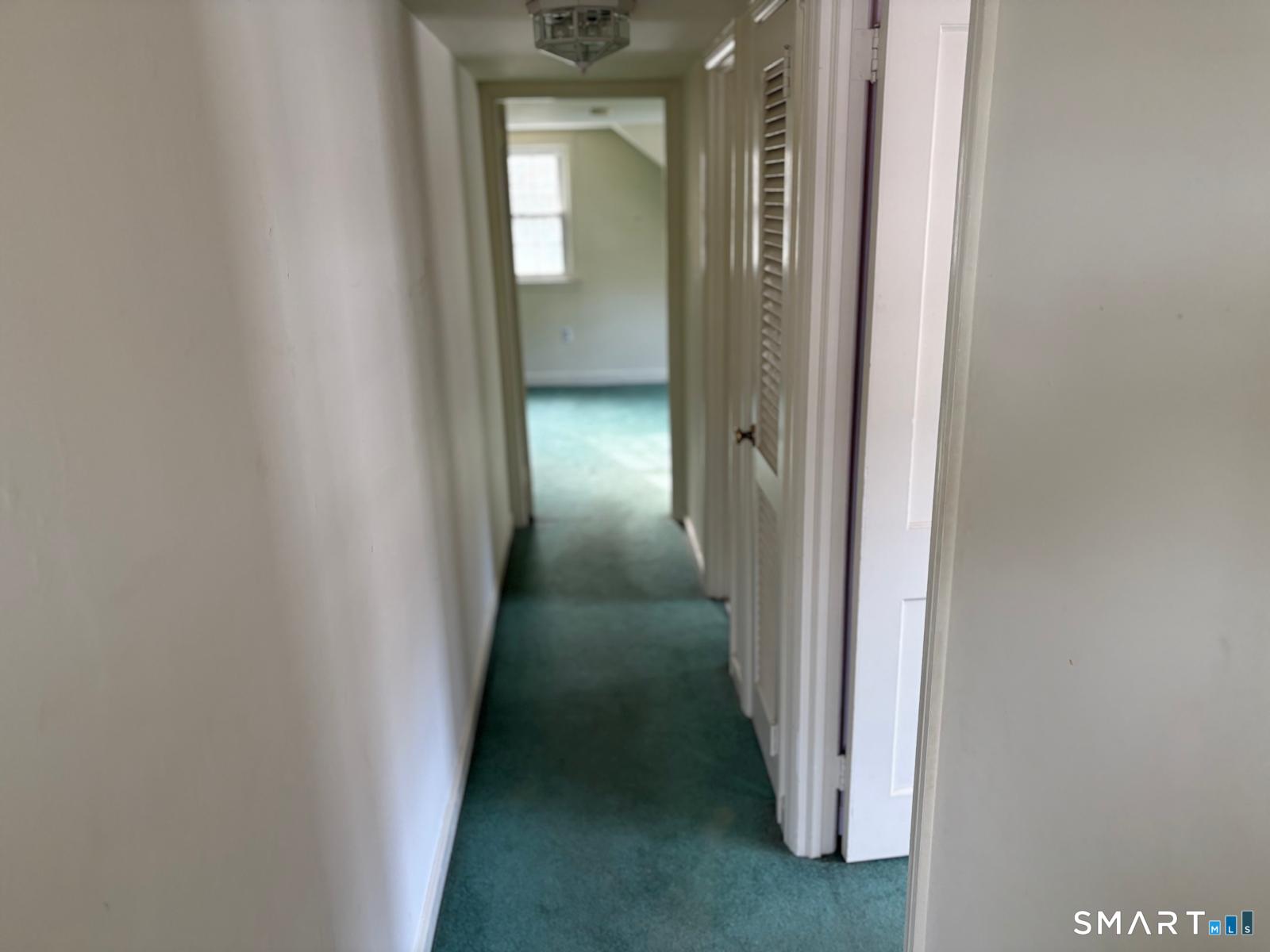 329 Bronson Road Fairfield, CT 06890 - Photo 13 of 25 a view of a hallway with a wooden door