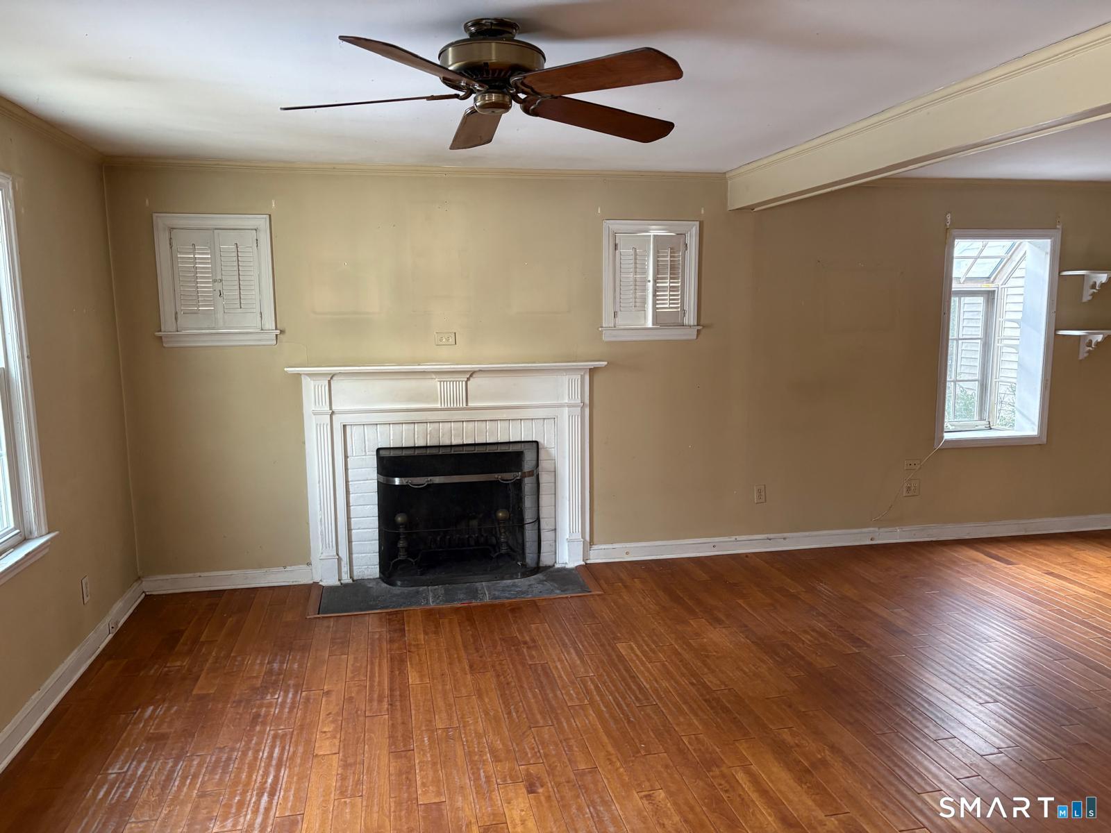 329 Bronson Road Fairfield, CT 06890 - Photo 4 of 25 a view of a livingroom with a fireplace window and wooden floor