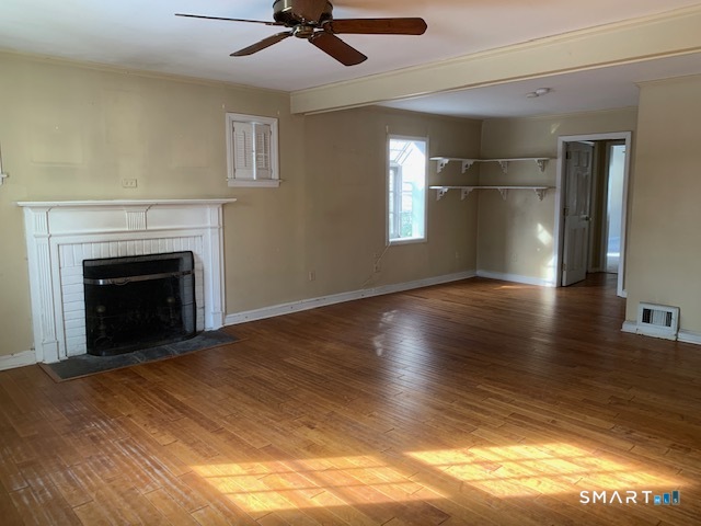 329 Bronson Road Fairfield, CT 06890 - Photo 5 of 25 a view of empty room with wooden floor and fireplace