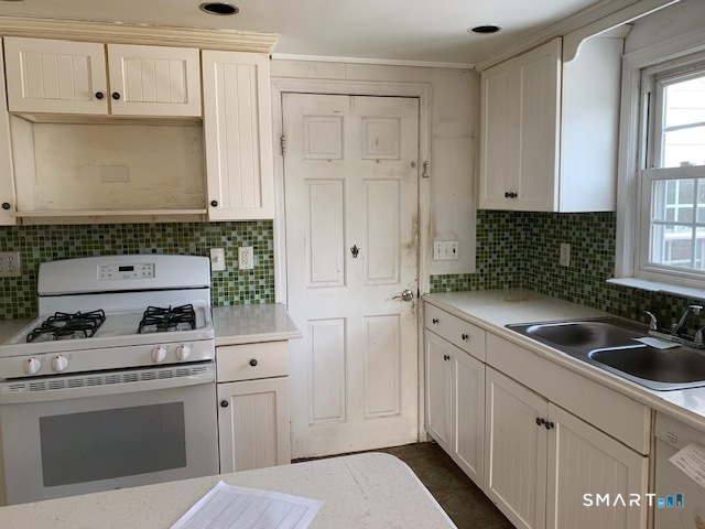 329 Bronson Road Fairfield, CT 06890 - Photo 8 of 25 a kitchen with white cabinets and white appliances