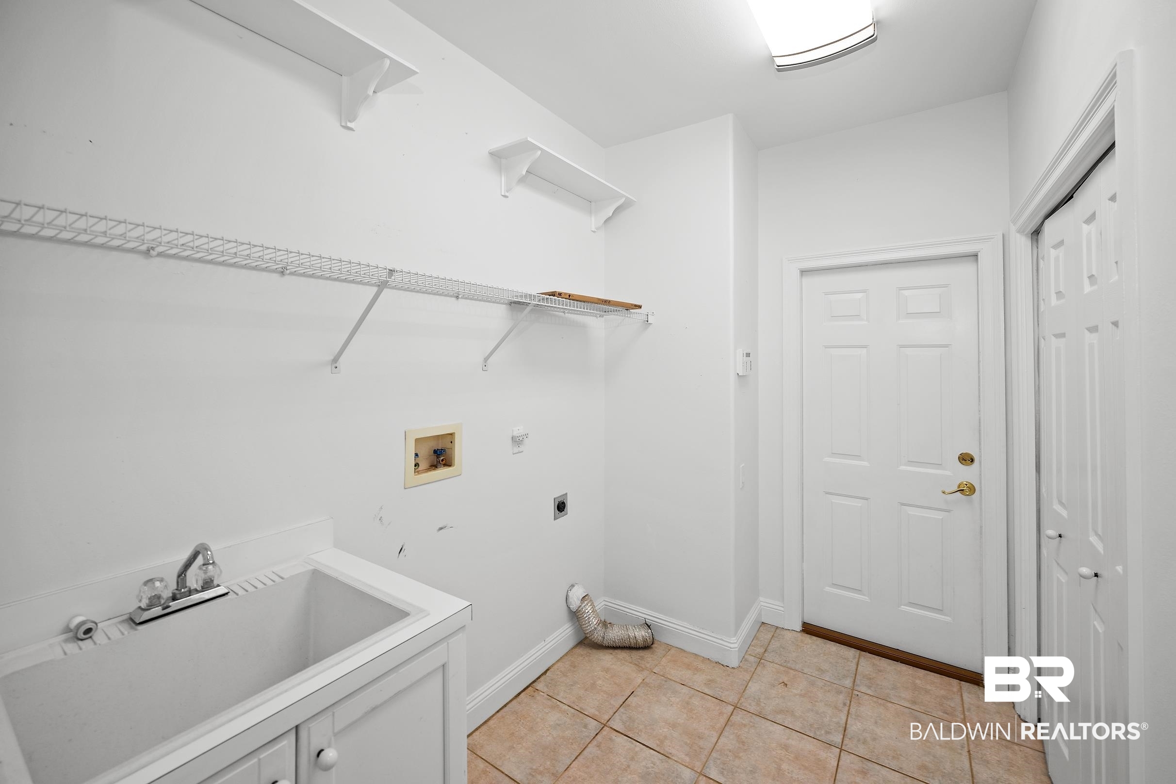 8591 Bay Harbor Road Elberta, AL 36530 - Photo 41 of 56 Washroom with light tile patterned floors, hookup for an electric dryer, and washer hookup