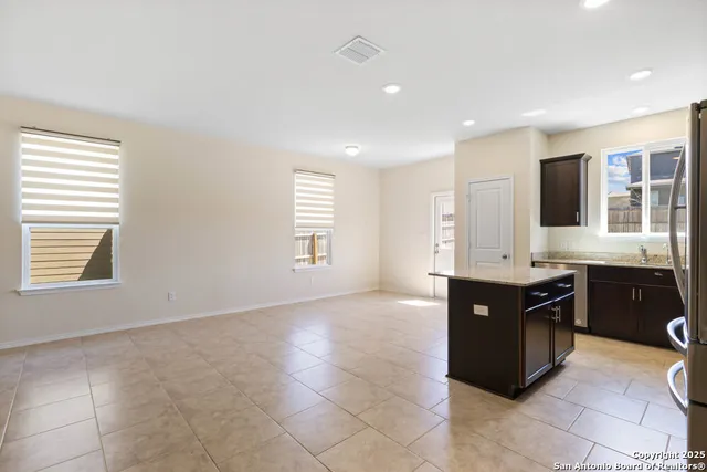 a large kitchen with granite countertop a stove a sink a window and dining table