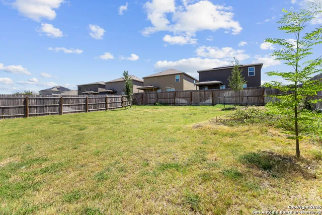 a view of a house with a big yard and large trees