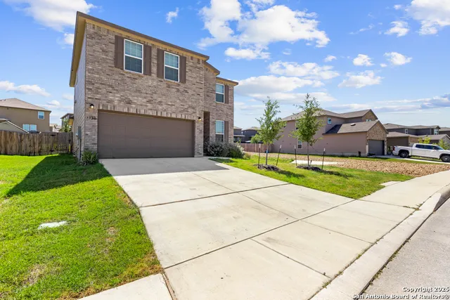 a front view of a house with a garden and yard