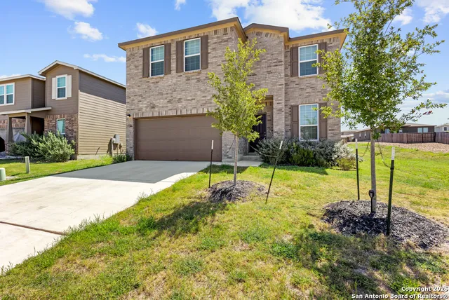 a view of a house with backyard and a tree
