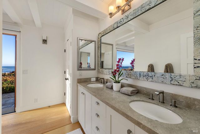 a bathroom with double vanity sinks and a mirror