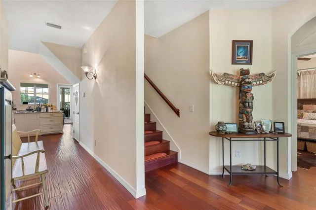 a living room with furniture and a bookshelf with wooden floor