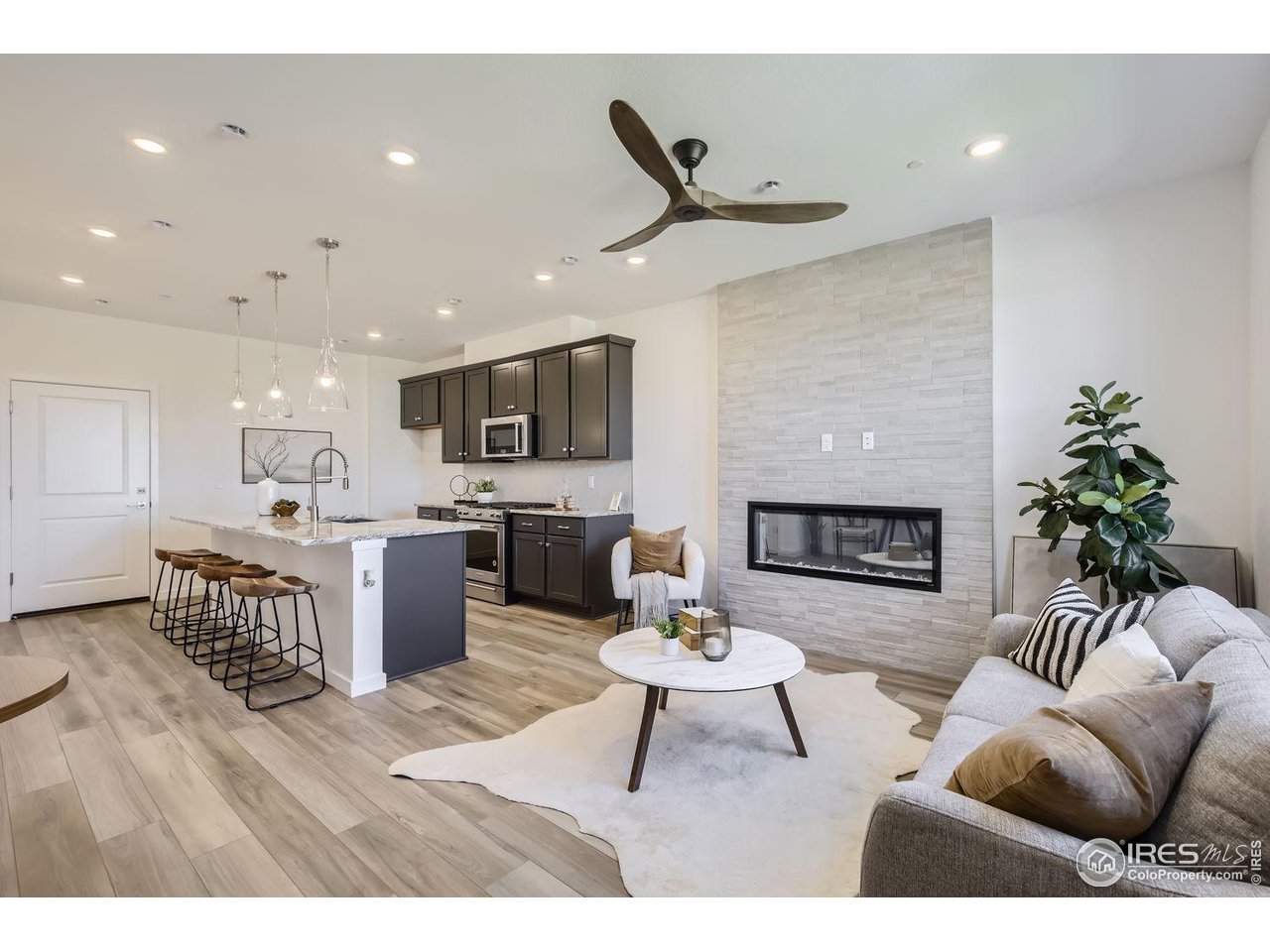 2721 Bear Springs Circle Longmont, CO 80503 - Photo 2 of 27 a living room with furniture a fireplace and a kitchen view