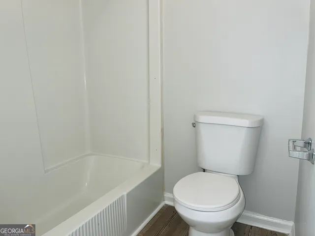 a white toilet sitting next to a bath tub