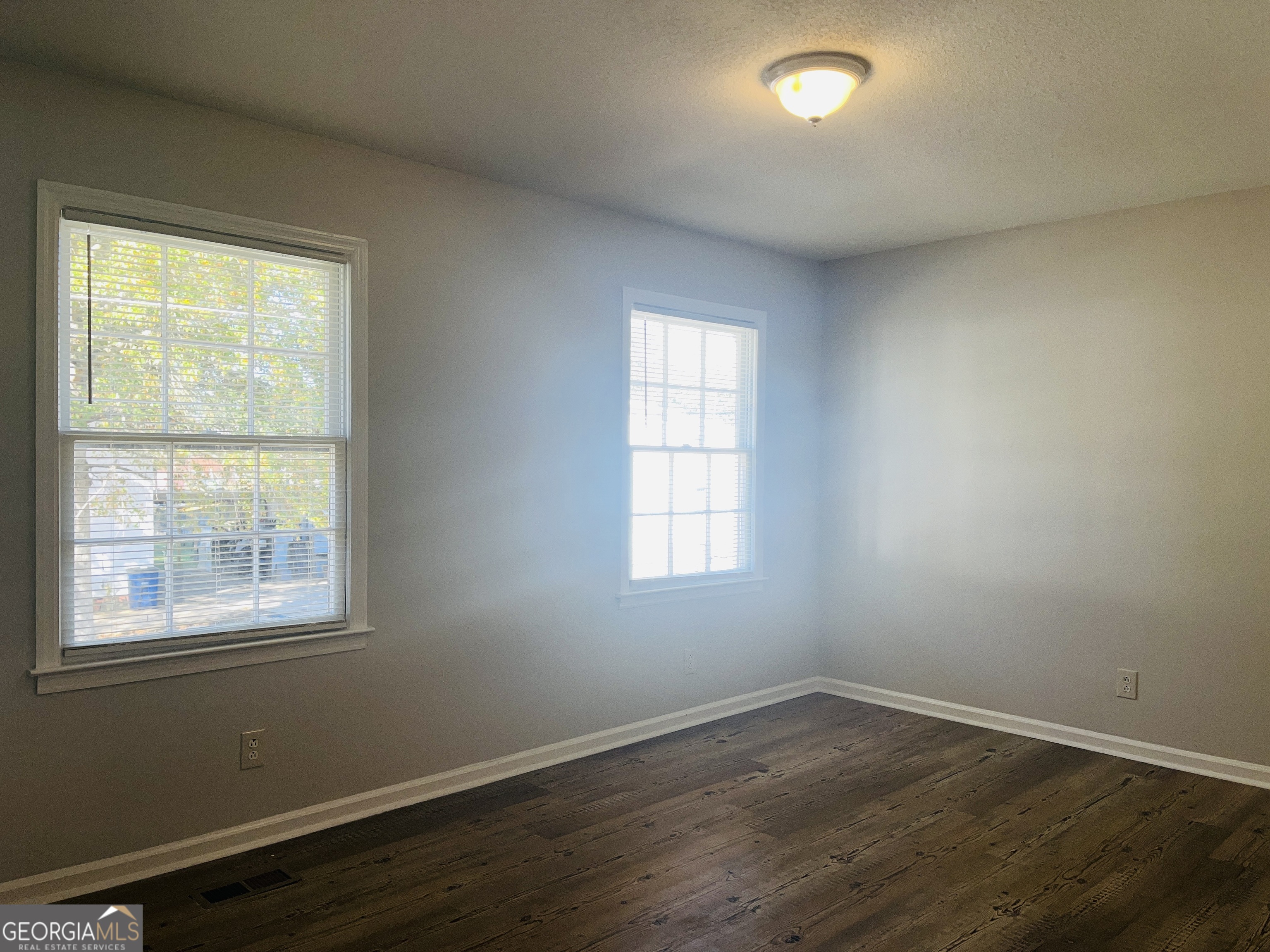 17 Curran Avenue, Unit A LaGrange, GA 30241 - Photo 21 of 25 an empty room with wooden floor and windows
