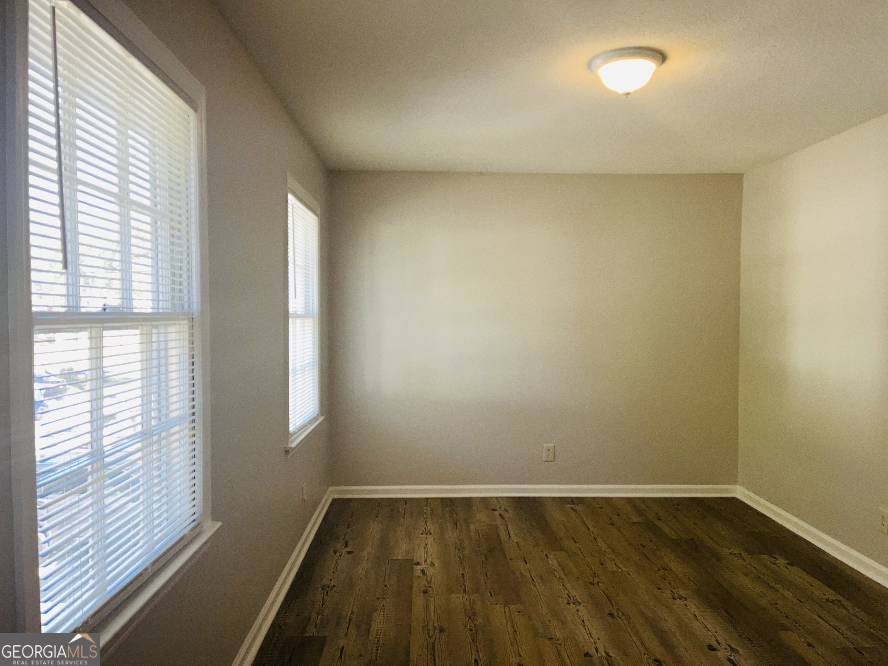 17 Curran Avenue, Unit A LaGrange, GA 30241 - Photo 22 of 25 a view of an empty room with wooden floor and a window