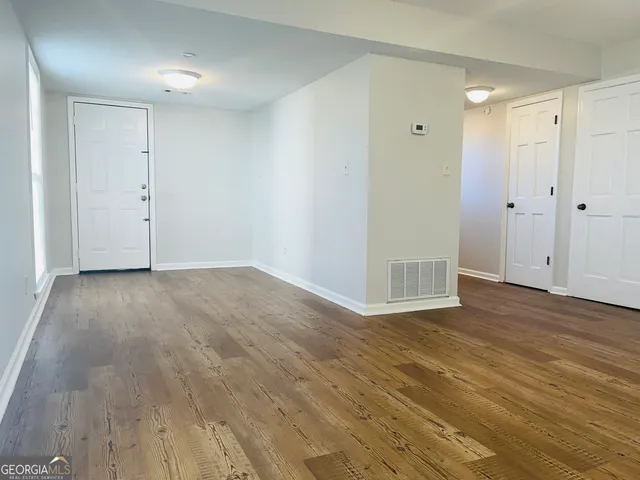 a view of an empty room with wooden floor