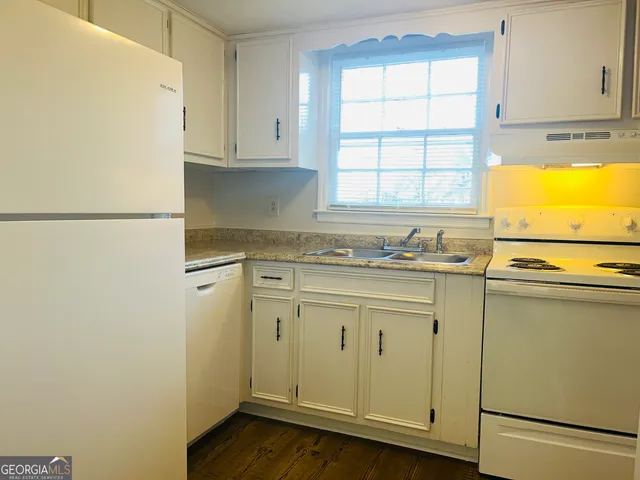 a bathroom with a granite countertop sink and a window