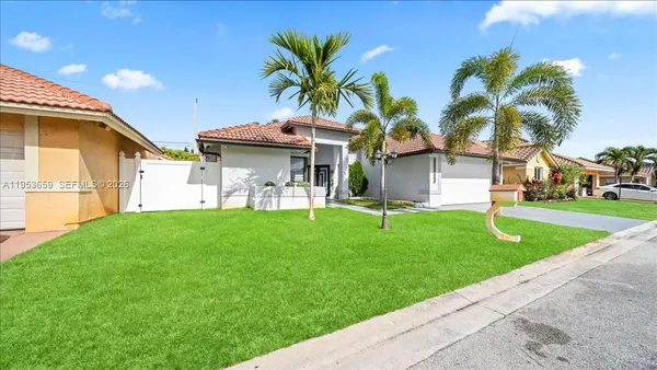 a front view of a house with a garden and yard