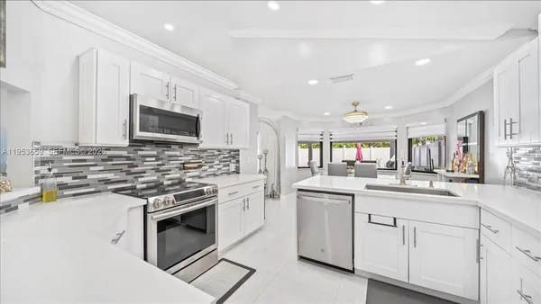 a kitchen with white cabinets appliances and a sink