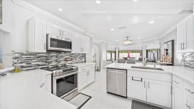 a kitchen with white cabinets appliances and a sink