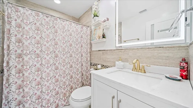 a bathroom with a sink a toilet and shower curtain