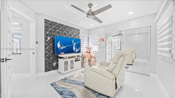 a living room with furniture a flat screen tv and a window