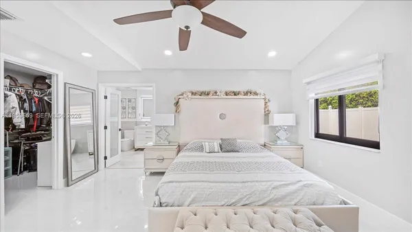 a bedroom with a large bed and a chandelier