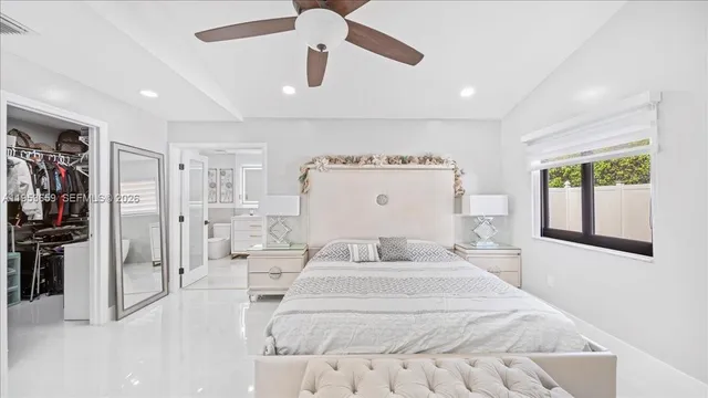 a bedroom with a large bed and a chandelier