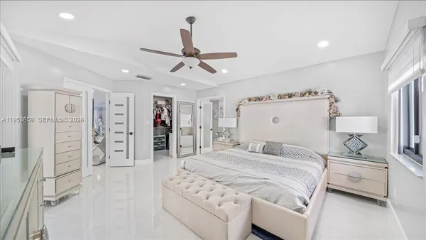 a bedroom with a large bed and a chandelier