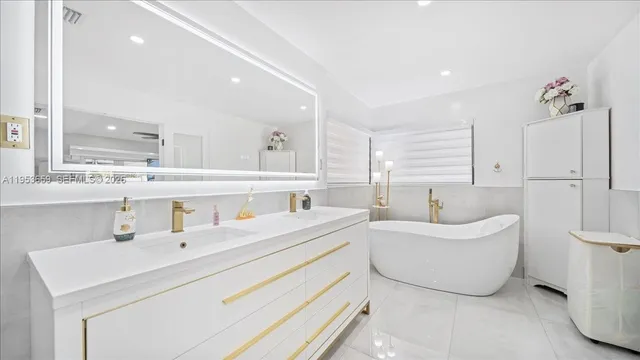 a bathroom with a double vanity sink mirror and bathtub