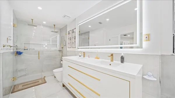 a bathroom with a double vanity sink mirror and shower