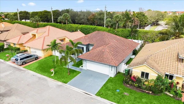 a view of a house with a yard and potted plants