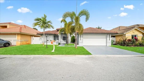 a front view of a house with a garden and plants