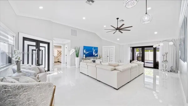 a living room with furniture a ceiling fan a rug and a ceiling fan