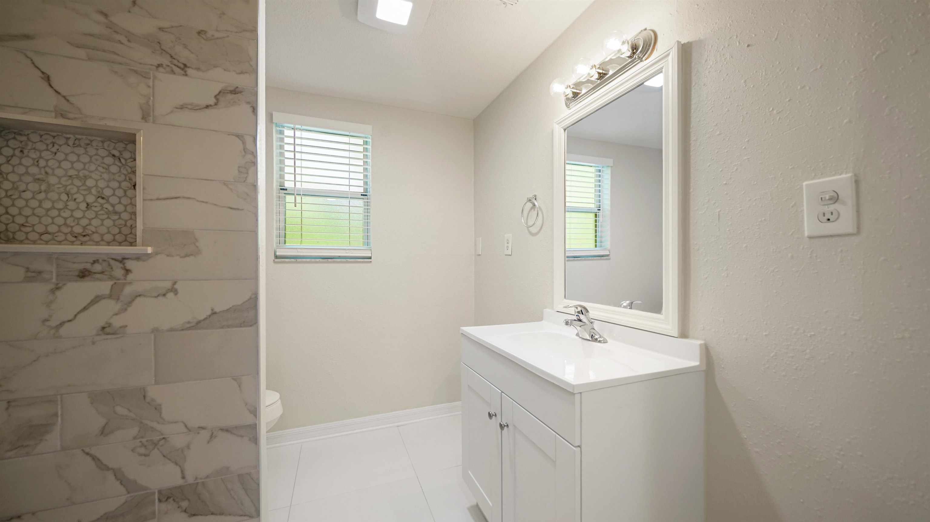 11734 Wynell Road Jacksonville, FL 32218 - Photo 15 of 27 a bathroom with a sink a mirror and a shower