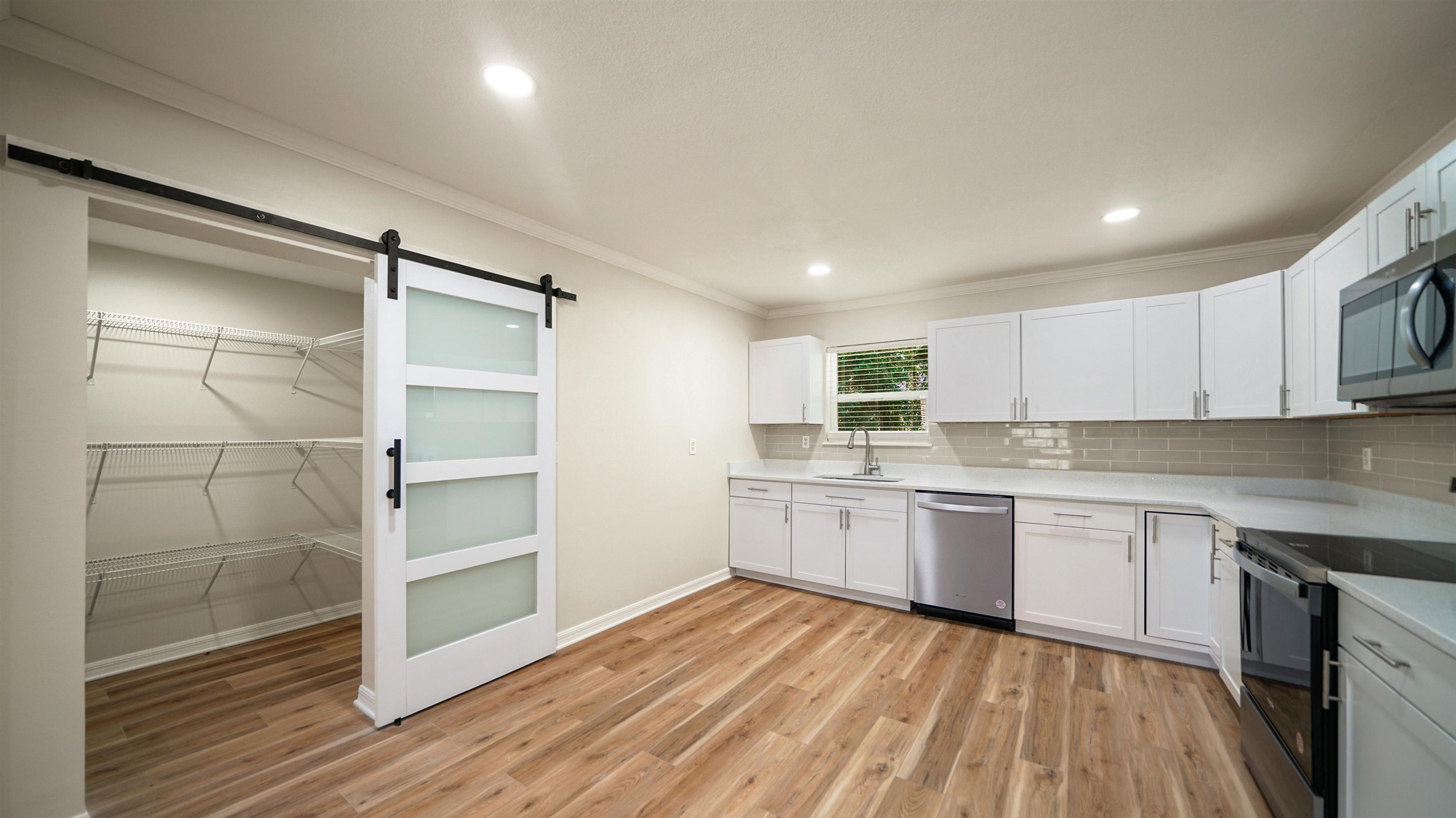 11734 Wynell Road Jacksonville, FL 32218 - Photo 5 of 27 a kitchen with wooden floors and white cabinets